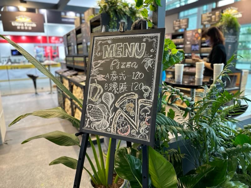 展位旁的手寫 MENU 黑板,畫著食材插圖