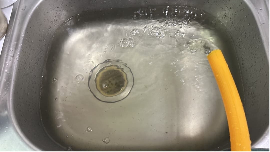 換水時排出的水在不鏽鋼水槽中呈現清澈