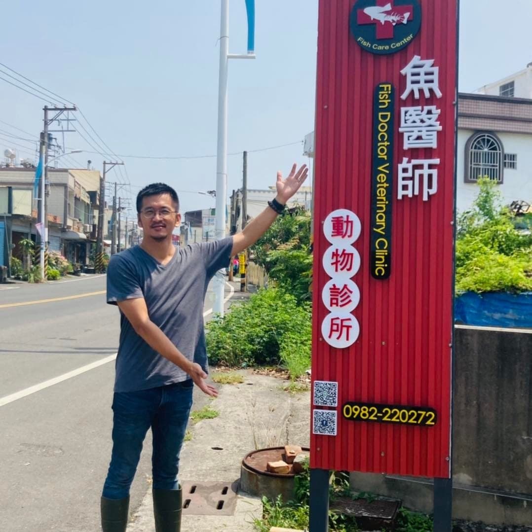 獸醫師站在「魚醫師動物診所」的招牌旁