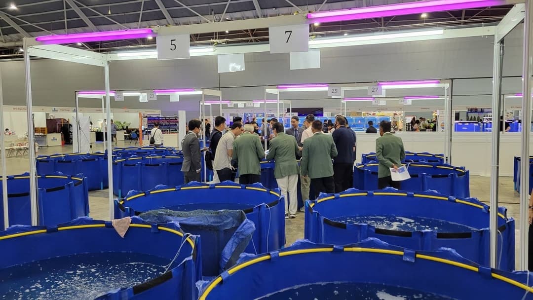 展場中成排的藍色圓形養殖池與參觀人群