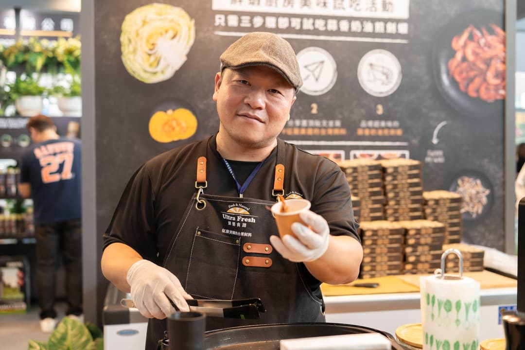 工作人員在展位的料理區遞出一份試吃
